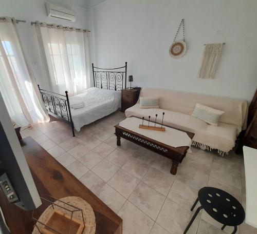 un salon avec un canapé et un lit dans l'établissement Louisa's Home, à Ermoúpoli
