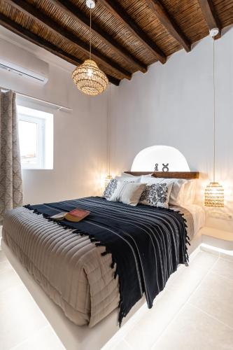 a bedroom with a large bed with a black blanket at Yria Traditional House in Vívlos