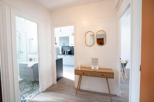 La salle de bains est pourvue d'un lavabo et d'une table. dans l'établissement Appartement T3 avec jardin, à Lanester