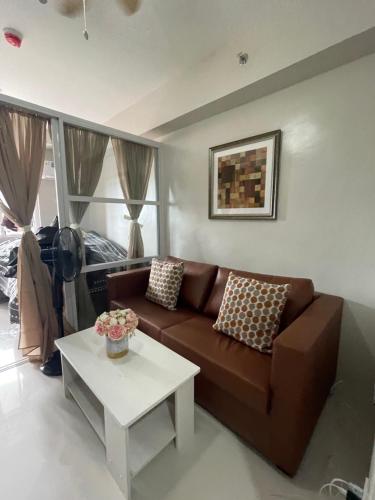 AgusにあるYvonne Condo at Primeworld Lapu Lapu, Mactan Cebuのリビングルーム(ブラウンソファ、テーブル付)