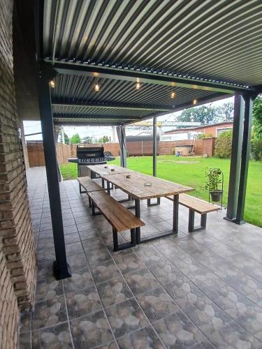 a picnic table with a grill under a pavilion at Hani's Partyhaus in Verl