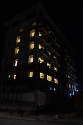 an apartment building with its lights on at night at Hotel Tea County in Dibrugarh