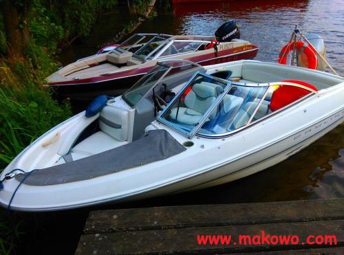 a white boat is docked at a dock at Letnisko BAJKA in Iława