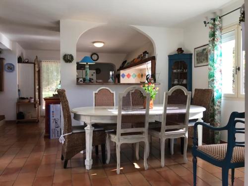 une salle à manger avec une table et des chaises blanches dans l'établissement Villa 190 m2 en bord de mer, à Pietrosella