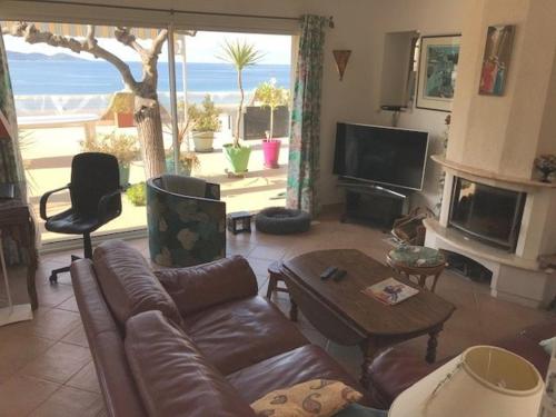 un salon avec un canapé, une table et une télévision dans l'établissement Villa 190 m2 en bord de mer, à Pietrosella