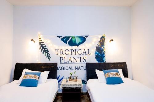 two beds in a room with a sign that says tropical plants at Jinan Mountain and Sea Culture Hotel in Jinan