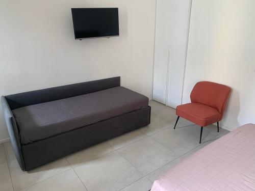a bedroom with a bed and a red chair at Harmony Navigli Apartment in Milan