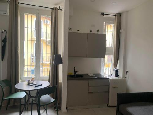 a small kitchen with a small table and a table and chairs at Harmony Navigli Apartment in Milan