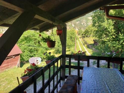 a balcony with a table and a view of a farm at Vikendica kod Brice in Jevtići