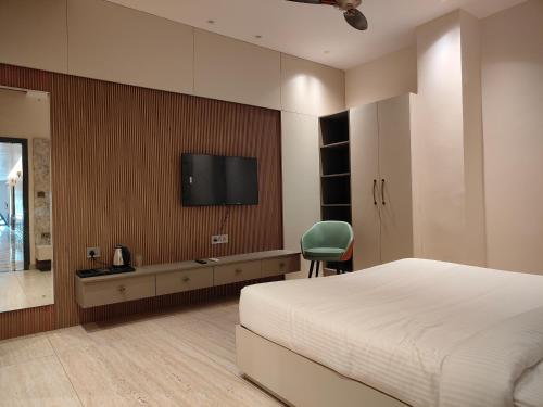 パティヤーラーにあるHotel Edissonのベッドと壁掛けテレビのある寝室