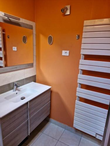 une salle de bain avec un lavabo et un miroir dans l'établissement Charmante maison de vacances, à Lézignan-Corbières