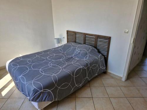 - un grand lit dans une chambre dotée d'un couvre-lit dans l'établissement Charmante maison de vacances, à Lézignan-Corbières