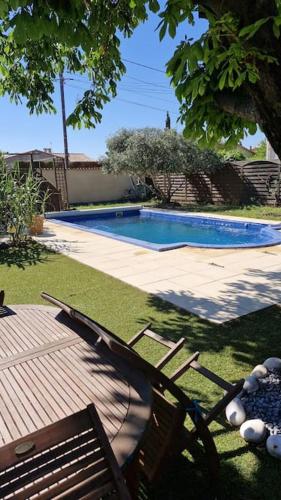 - une piscine dans une cour avec un banc dans l'établissement Charmante maison de vacances, à Lézignan-Corbières