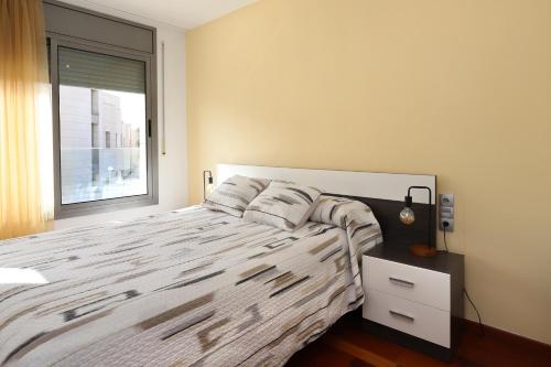 een slaapkamer met een groot bed en een raam bij AT014 A pocos metros de la playa, equipamiento completo, piscina comunitaria in Torredembarra