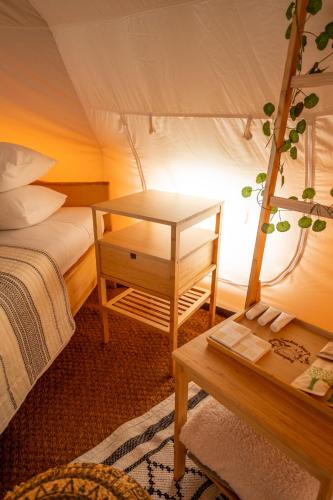 a room with a bed and a table in a room at Glamping Gozdna Jasa in Bovec