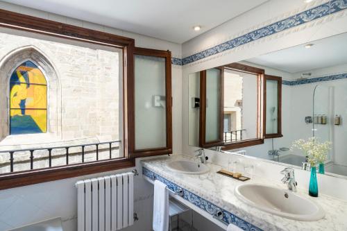 a bathroom with two sinks and a window at Parador de Santo Domingo de la Calzada in Santo Domingo de la Calzada