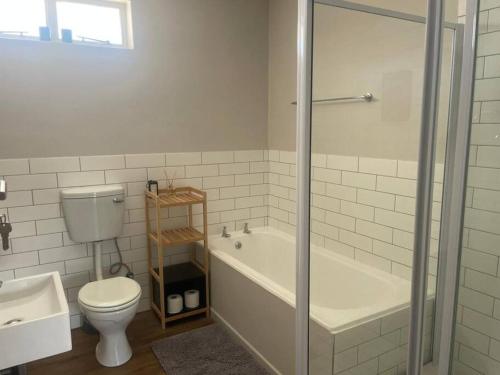 een badkamer met toilet, bad en wastafel bij Royal Mountain Apartment in Paarl