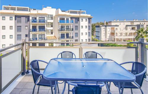 a blue table and chairs on a balcony with buildings at 2 Bedroom Lovely Apartment In Oliva in Oliva