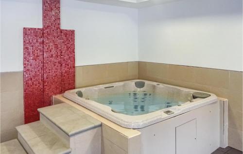 a jacuzzi tub in a room with a red wall at 2 Bedroom Lovely Apartment In Oliva in Oliva
