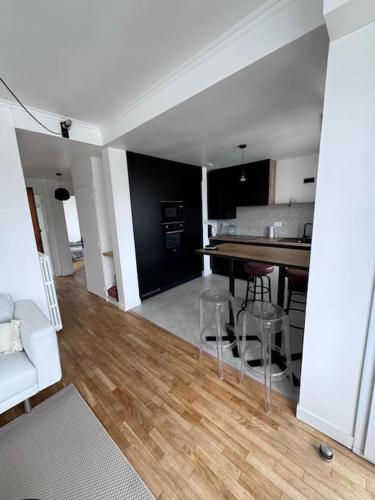 un salon avec un canapé blanc et une cuisine dans l'établissement Charmant appartement t3 avec balcon, centre-ville, à Lorient