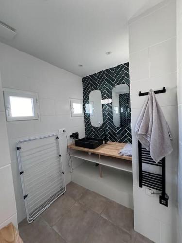 une salle de bain avec un lavabo et deux miroirs dans l'établissement Charmant appartement t3 avec balcon, centre-ville, à Lorient