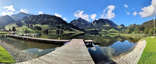 a dock on a lake with mountains in the background at Ferienwohnung Kassler in Schwarzsee
