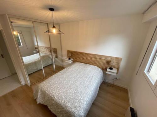 une chambre avec un lit et un grand miroir dans l'établissement Appartement T3 rénové à 5 min de la plage - Fréjus, à Fréjus