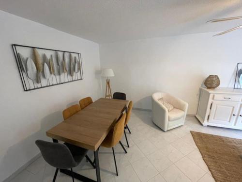 une salle à manger avec une table et des chaises en bois dans l'établissement Appartement T3 rénové à 5 min de la plage - Fréjus, à Fréjus