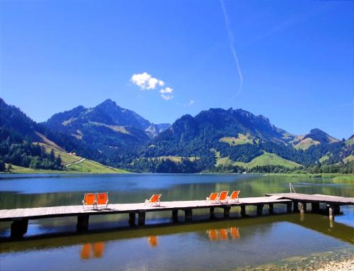 a dock on a lake with chairs on it at Ferienwohnung Kassler in Schwarzsee