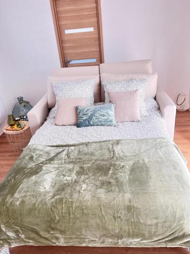 - une chambre dotée d'un grand lit avec des oreillers roses et bleus dans l'établissement La belle Iris, à Longueau