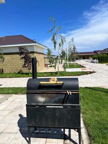 a black stove sitting on the grass in front of a building at Palm beach 10 in Chok-Tal
