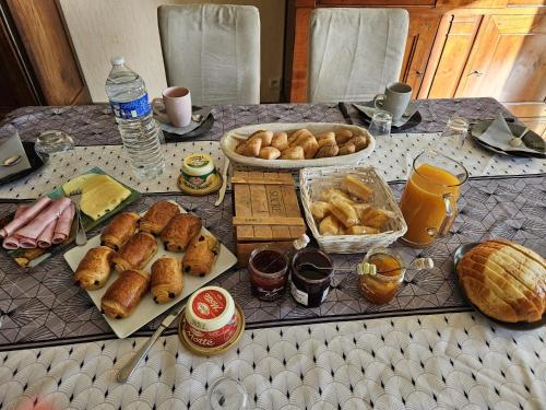 ein Tisch mit Brot und anderen Speisen darauf in der Unterkunft Séjour circuit 24h du Mans in Saint-Jean-du-Bois