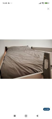 - un lit avec des draps bruns au-dessus dans l'établissement Charmant appartement 4 personnes près de la mer, à Argelès-sur-Mer