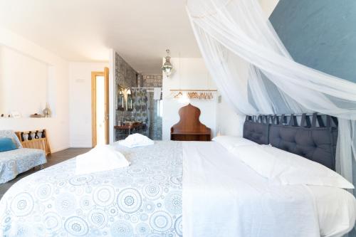 a bedroom with a white bed with a blue canopy at Ajamola in Favignana