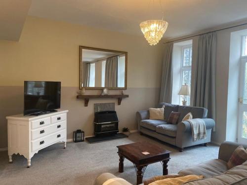 a living room with a couch and a television at Ash Cottage in Windermere