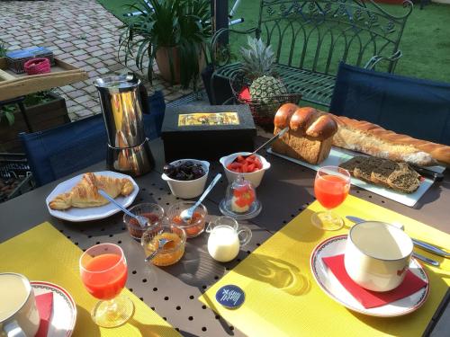 une table avec des aliments et des boissons pour le petit-déjeuner dans l'établissement La Foulonnière de Neuville, à Neuville-sur-Saône