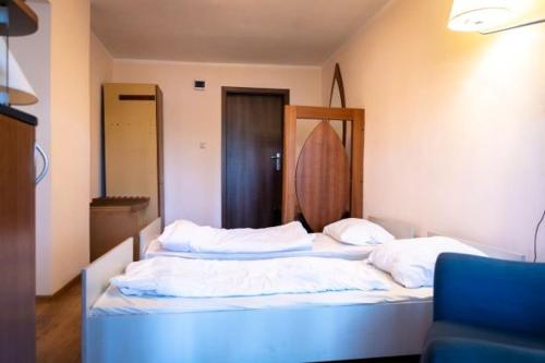 a bedroom with two beds and a blue chair at Przystań Lubniewice - Pokoje Gościnne in Lubniewice