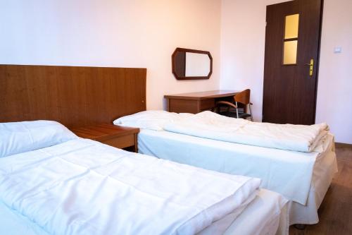 two beds in a room with a table and a mirror at Przystań Lubniewice - Pokoje Gościnne in Lubniewice