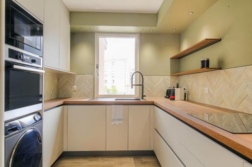 eine Küche mit Spüle und Herd Oberer Backofen in der Unterkunft Luxe et Design avec parking gratuit in Lyon