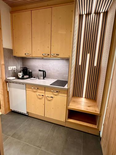 a kitchen with wooden cabinets and a sink at Apartment mit Indoor Pool und Garten in Sankt Martin bei Lofer