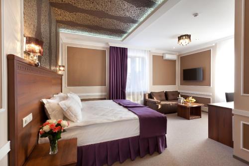une chambre d'hôtel avec un lit et un canapé dans l'établissement Chocolatier Hotel, à Krasnodar