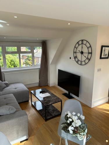 a living room with a large clock on the wall at Luxury Penthouse Appartment in Cobham