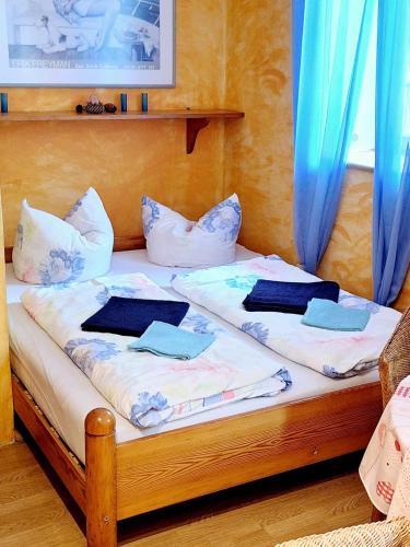 a wooden bed with blue curtains and pillows on it at Michałowa Zagroda 2 in Piechowice