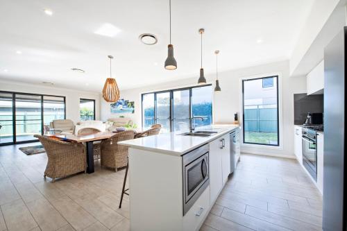 a kitchen and living room with a table and chairs at Macquarie Entertainer - Pool Retreat, Pet Friendly in Dubbo