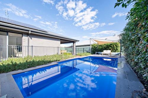 a swimming pool in the backyard of a house at Macquarie Entertainer - Pool Retreat, Pet Friendly in Dubbo