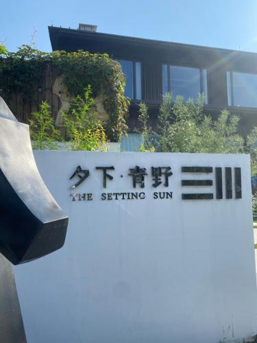 a sign for the setting sun in front of a building at 夕下青野民宿 The Setting Sun in Qiantan