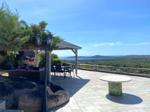 un patio avec une table et une table et une vue dans l'établissement Villa Alteto magnifique vue mer, piscine, à Zonza