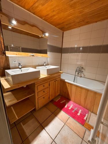 une salle de bain avec deux lavabos et une baignoire dans l'établissement Appartement Chamonix, à Chamonix-Mont-Blanc