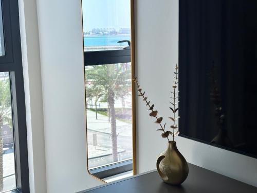 a vase sitting on a table in front of a window at Marassi Beach Residence Bahrain in Rayyā