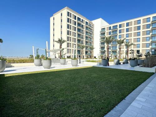a lawn in front of a large building at Marassi Beach Residence Bahrain in Rayyā